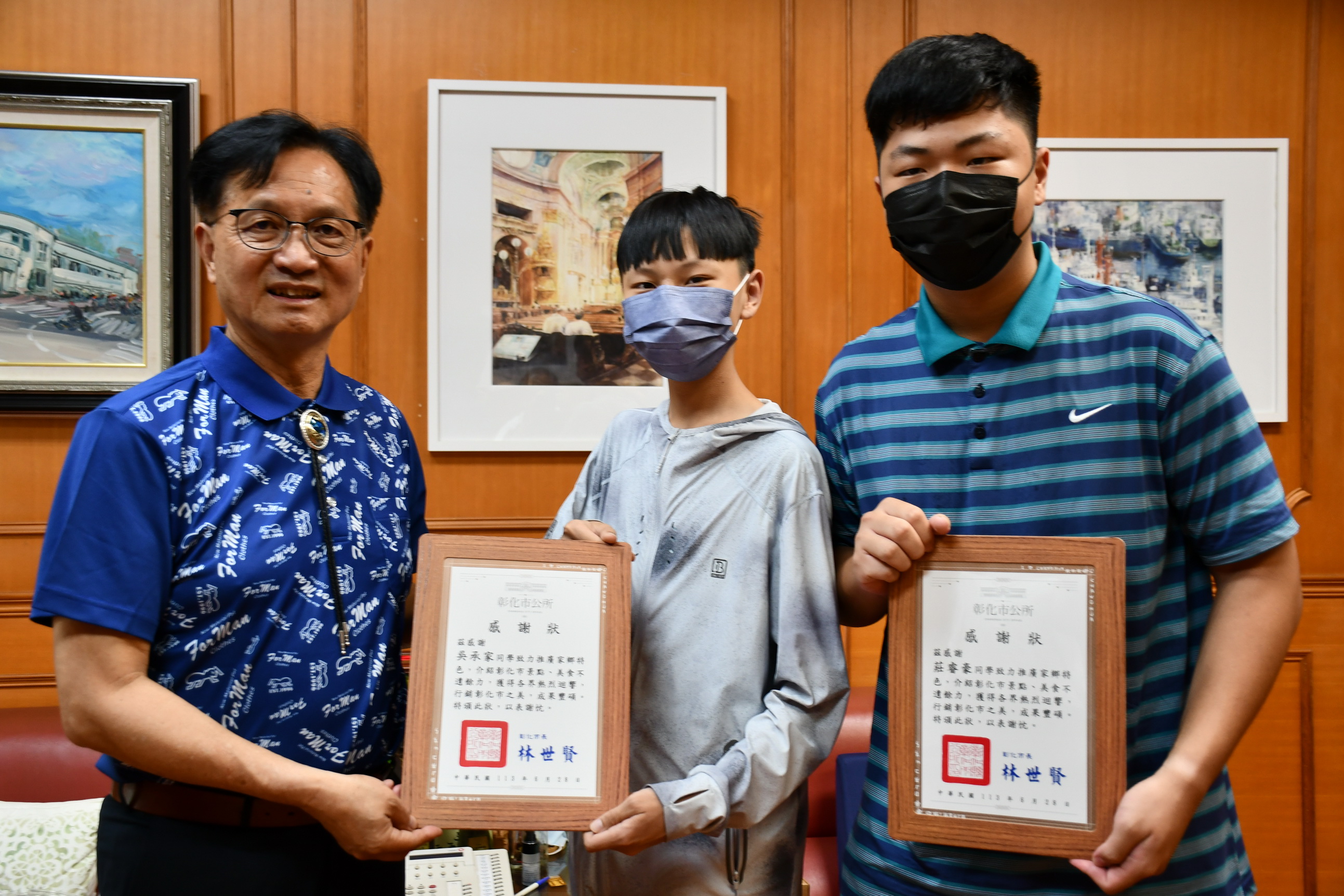 ▲彰化市長林世賢頒發感謝狀表揚「阿家」和「小莊」時，兩人導遊的影片觀看人數已達122萬，彰化市公所聘請兩人為終身「觀光大使」。（記者張溎壕攝）