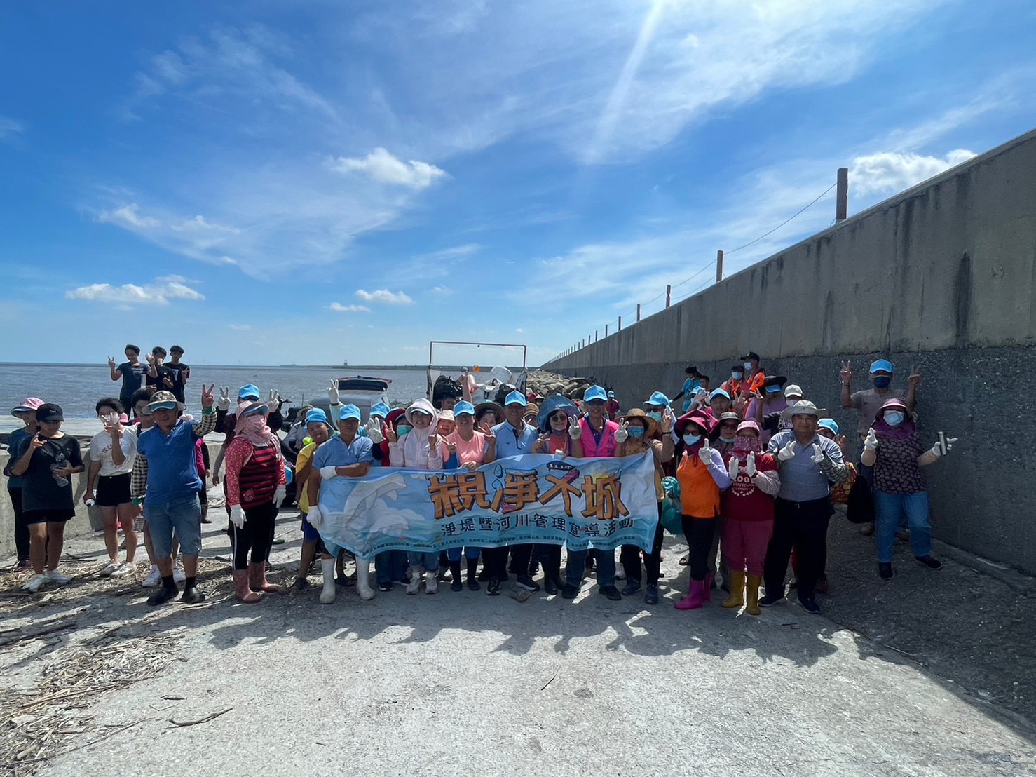 ▲大城鄉鄉公所號召社區民眾志工頂著大太陽，沿著海堤道路撿拾卡在海岸消波塊的廢棄物。（記者張溎壕攝）