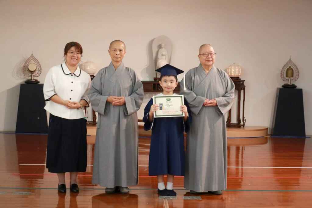 ▲靜思精舍德旭師父(右一)、德守師父(左二)、李靜芳園長(左一)為唯一畢業生吳宸賓送上祝福。(台中慈濟醫院提供)