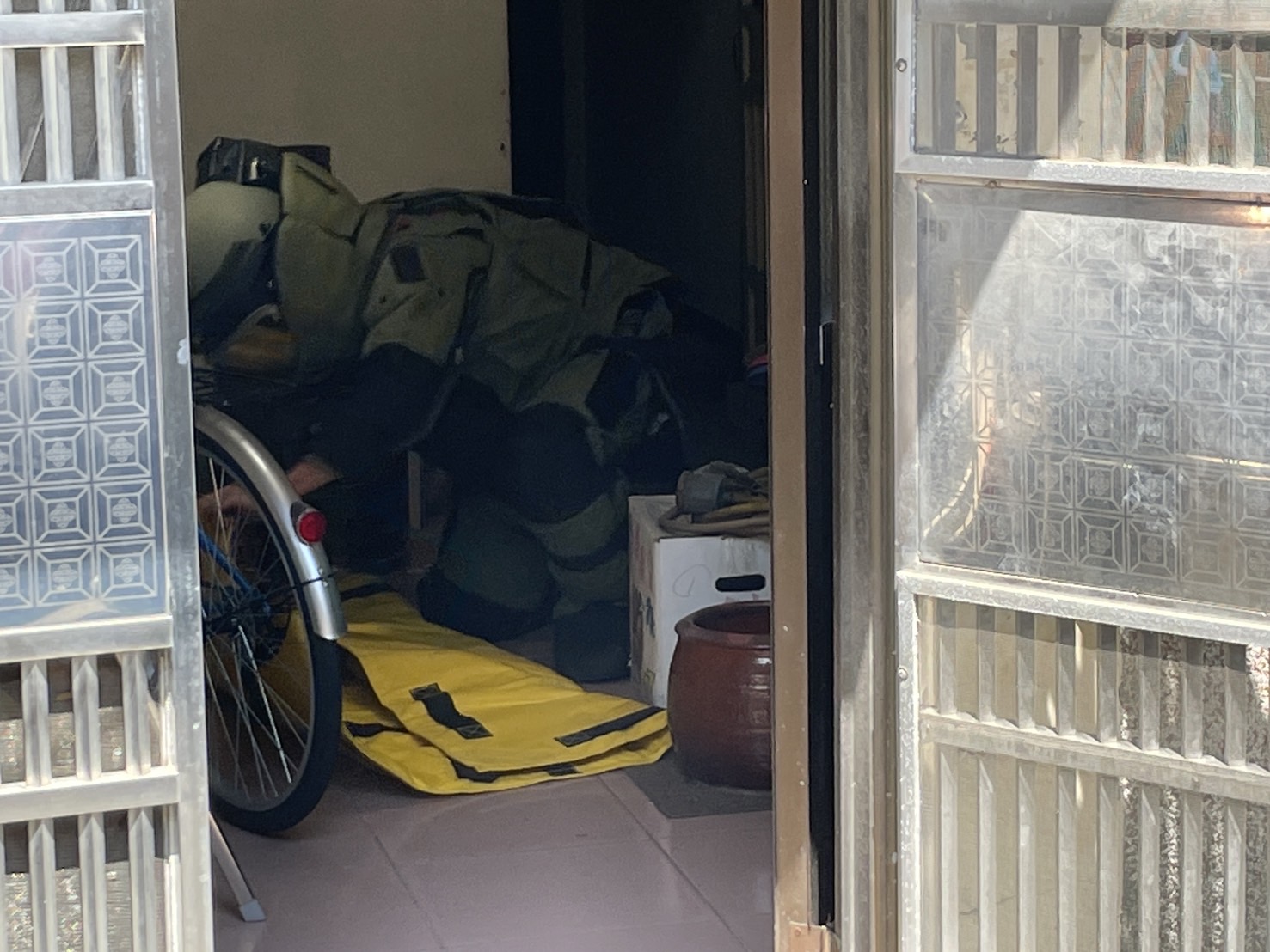 ▲員林市驚傳發現未爆彈，員東路二段一處民宅外洗手台下方被放置不明砲彈，警方獲報到場拉起封鎖線管制，國軍未爆彈處理小組派員帶回銷毀。（記者張溎壕翻攝）