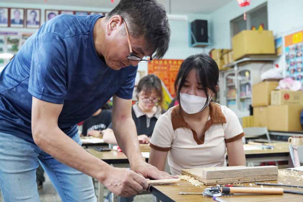 ▲大葉大學吉田敦老師(左)指導學員木工藝技巧。(大葉大學提供)