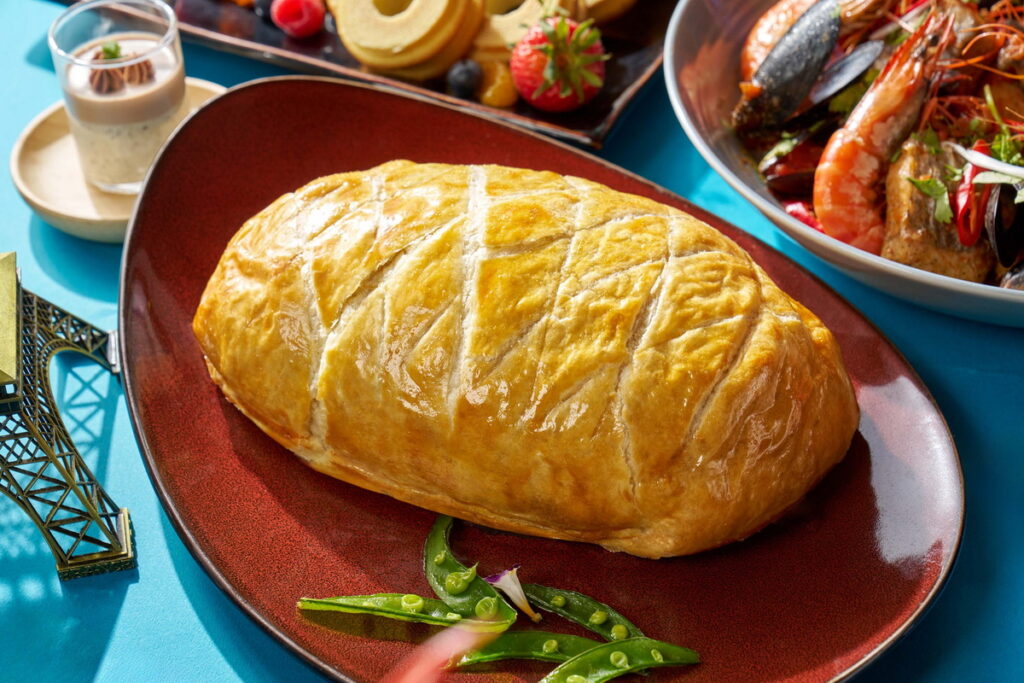 威靈頓牛排精選牛眼菲力牛排,經由煎烤後再加入自製法式蘑菇泥及帕瑪火腿,最後包裏於奶油酥皮中(台北福華大飯店提供)