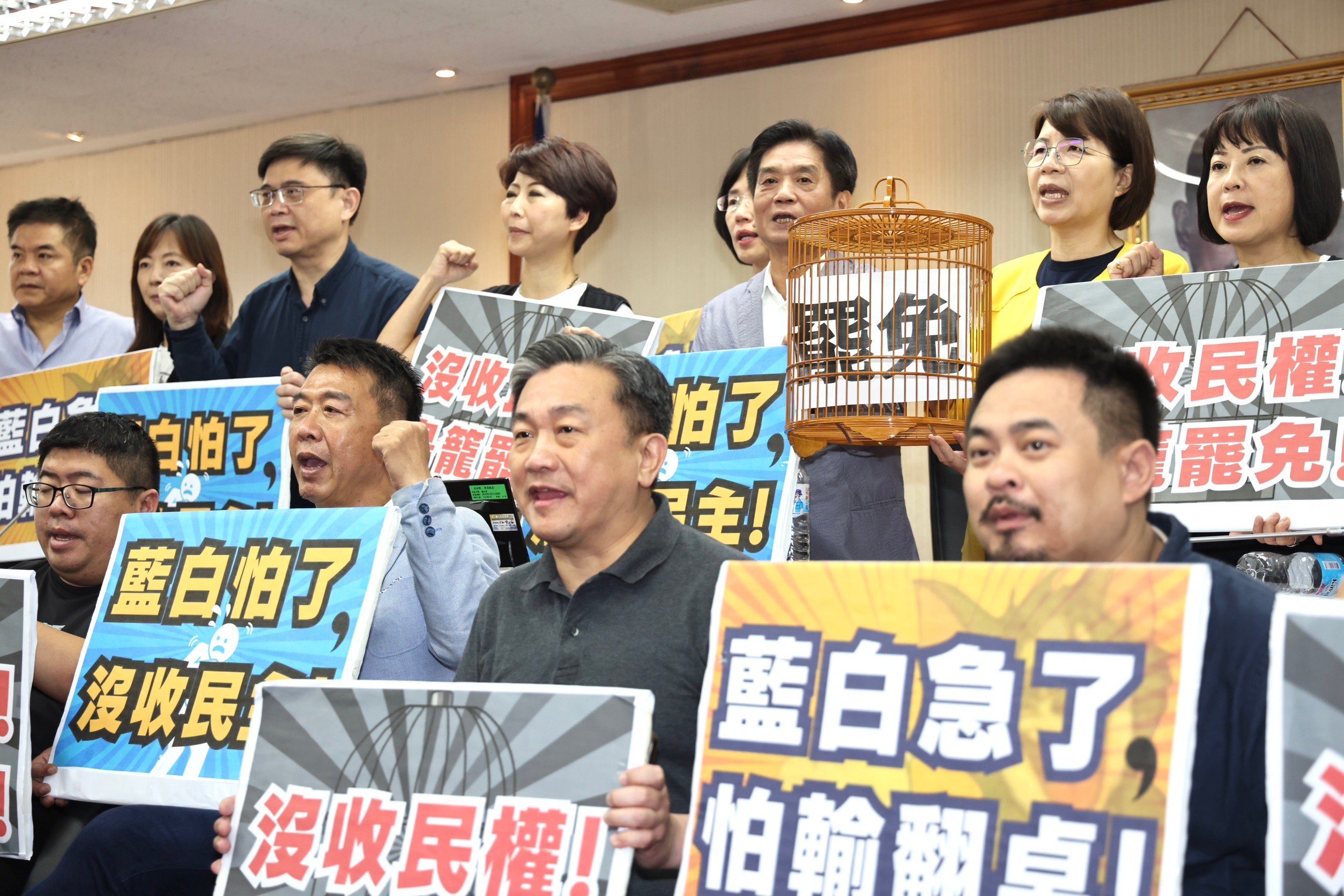 民進黨立委王定宇（中）等人3日帶著鳥籠，持「沒收民權 鳥籠罷免」手牌表達立場。林啟弘攝