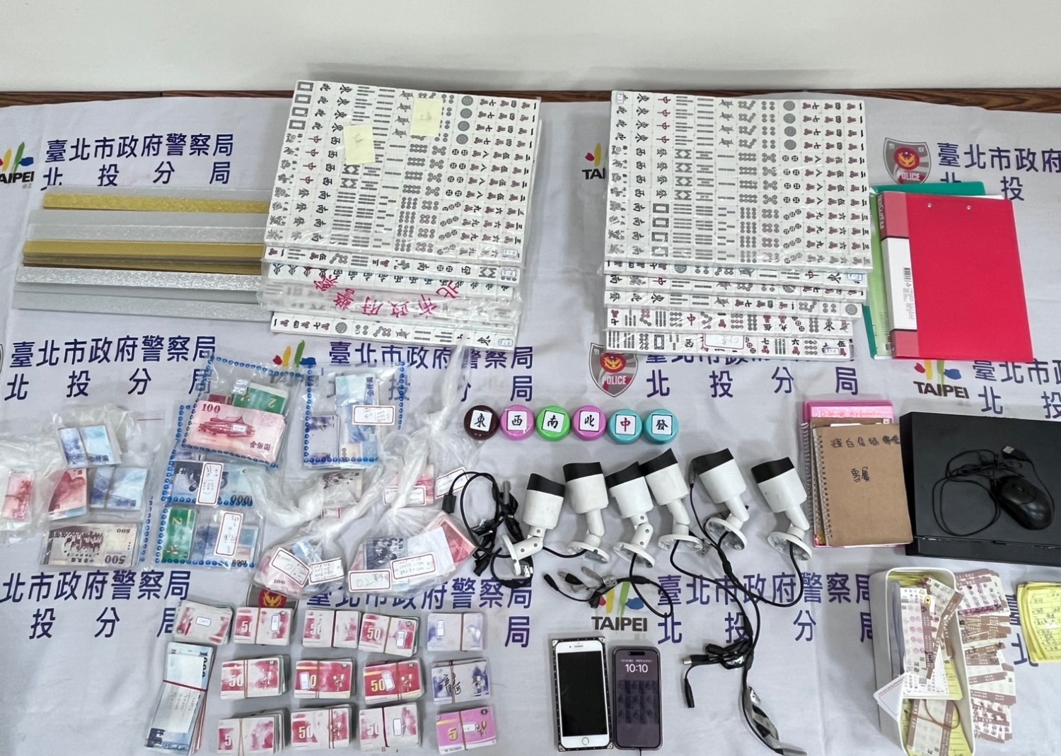 北投分局警員搜查賭場現場,查扣大量賭資及賭具。(記者薛秀蓮翻攝)
