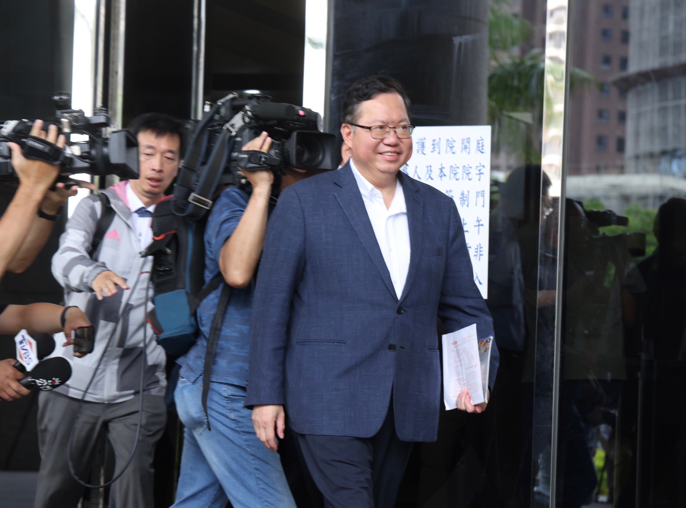 海基會董事長鄭文燦帶著微笑步出桃園地檢,面對媒體記者的包圍追問,他不發一語上車離去。林啟弘攝