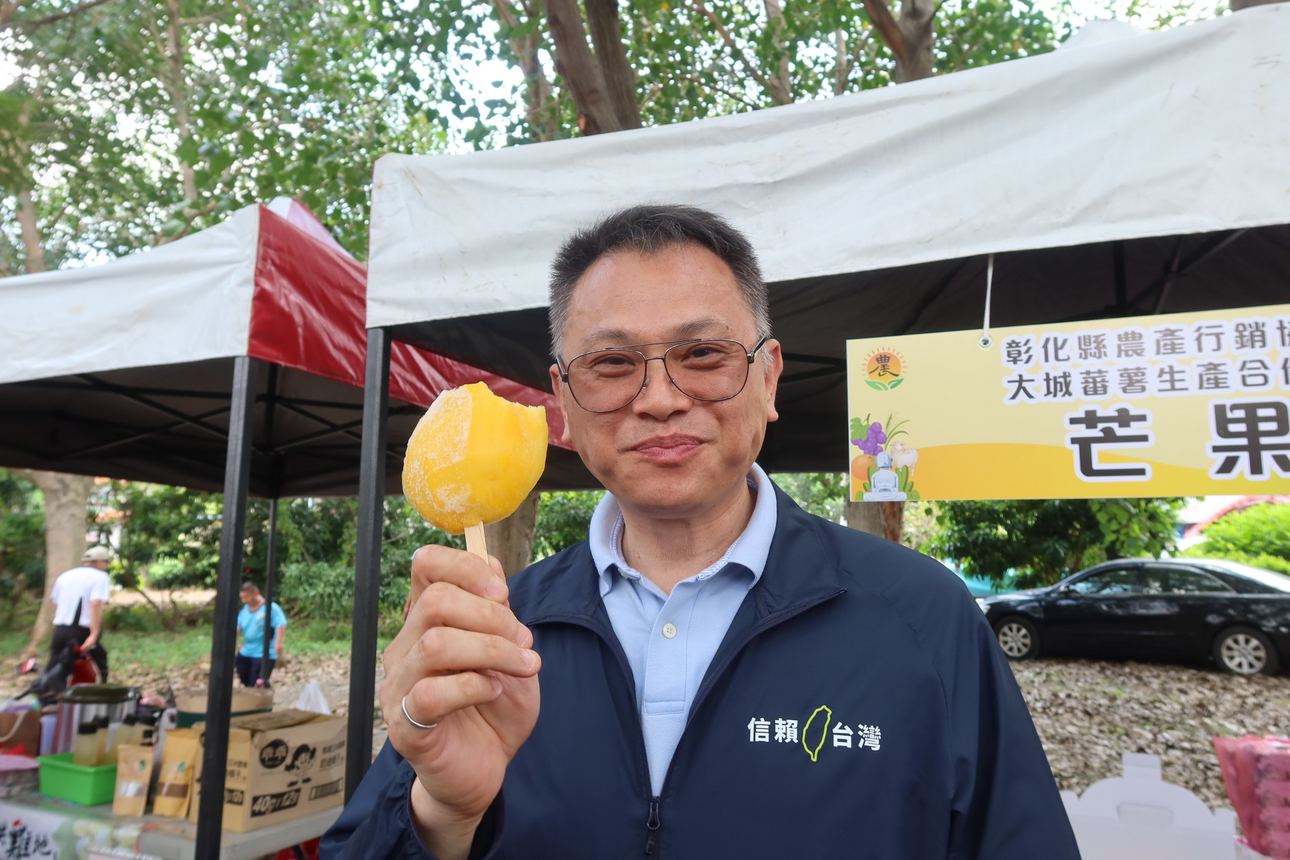 ▲彰化縣金蜜芒果暨蕃薯囡仔行銷品嚐公益活動在埔心鄉梧鳳公園舉辦,吸引上千位民眾排隊嚐「平民款冰棒」,男女老少直呼「透心涼」。(記者張溎壕攝)