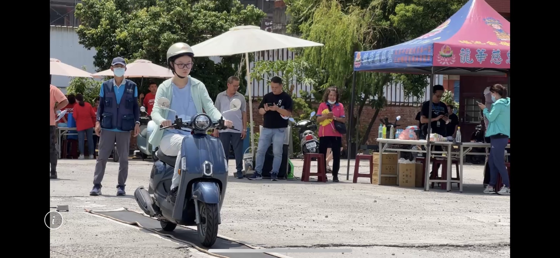 ▲彰化監理站在和美鎮辦理機車下鄉考照,名額僅有70個,吸引了眾多考生和家長前來參與,考生頂著大太陽進行機車路考。(記者張溎壕攝)