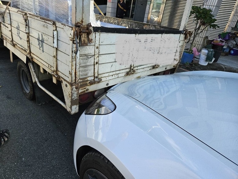 王先生駕車在等紅綠燈時,前方貨車司機因未注意到後方有車,突然倒車,直接撞上他的特斯拉。(記者 趙靜姸翻攝)