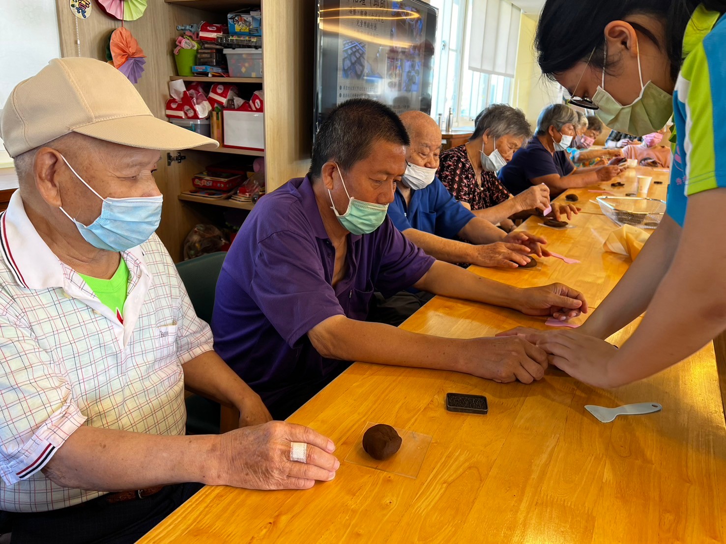▲福興秀和苑日照中心邀請鹿港手手桂花工作坊的邱怡瑄老師，指導阿公阿嬤們製作香牌。（記者張溎壕攝）