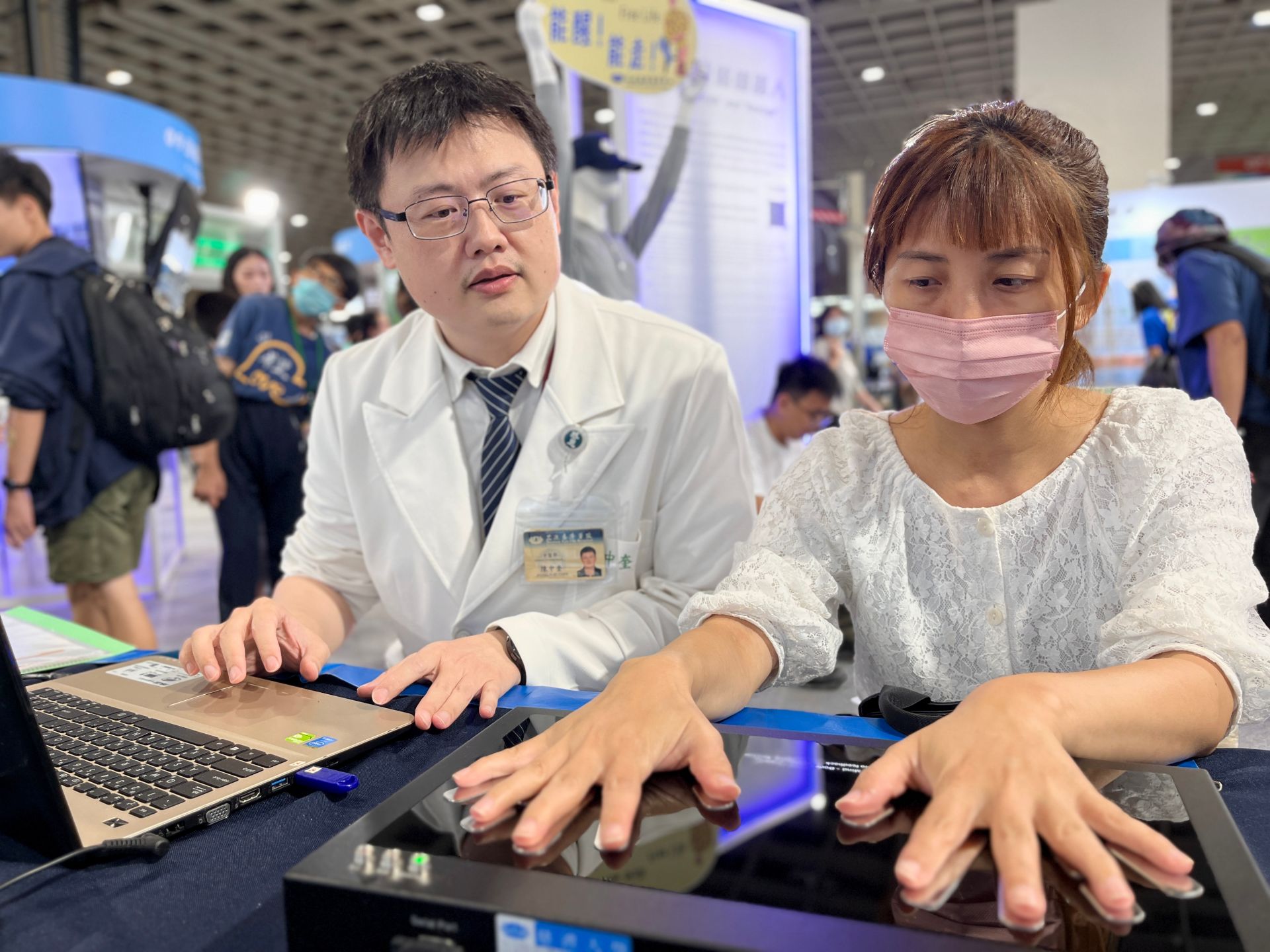 陳中奎醫師(左)操作能量檢測儀,為民眾解說。