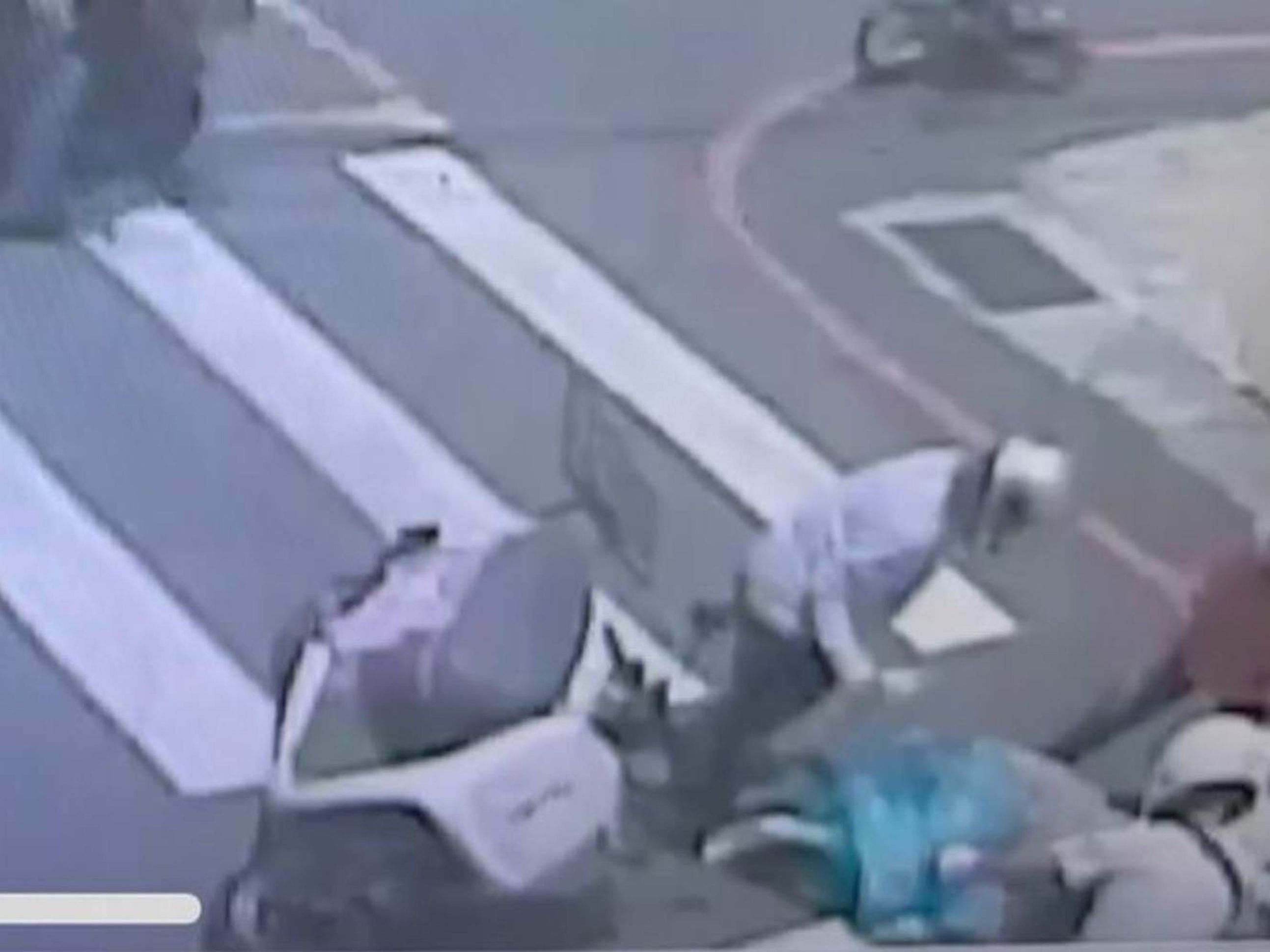 ▲彰化市發生一起機車與轎車碰撞車禍，適逢中午柏油路面滾燙，有人撐傘為倒地的女子遮陽防曬傷。（民眾提供）