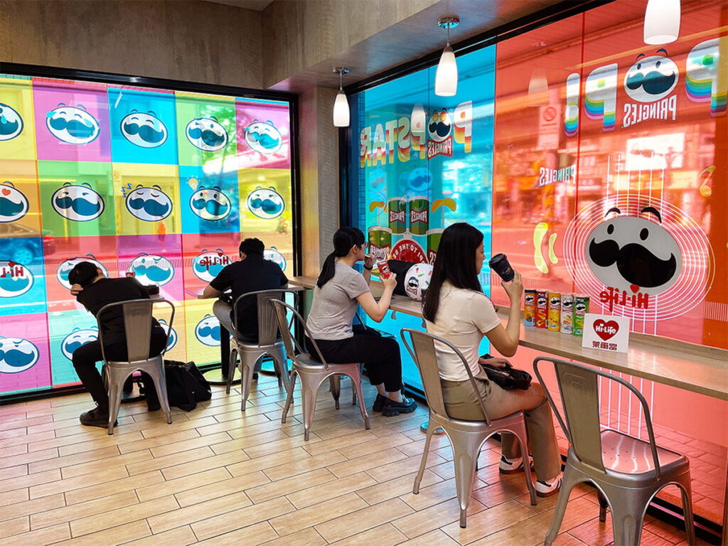 萊爾富「品客特色主題店」打造出舒適的超商休憩空間，櫥窗貼上生動活潑的樂團與運動形象玻璃貼，傳達品客活潑歡樂的品牌形象