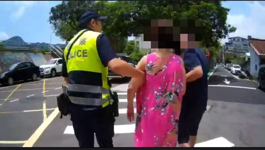 木新派出所警員將失智陳婦哄回路邊再配合其子將陳婦護送返家。(記者 張艷君翻攝)