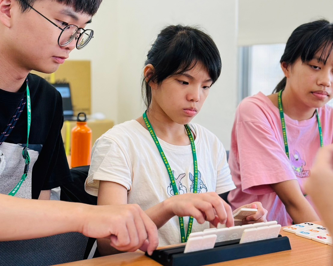 暑期實習生(左)與學生們一同投入桌遊當中
