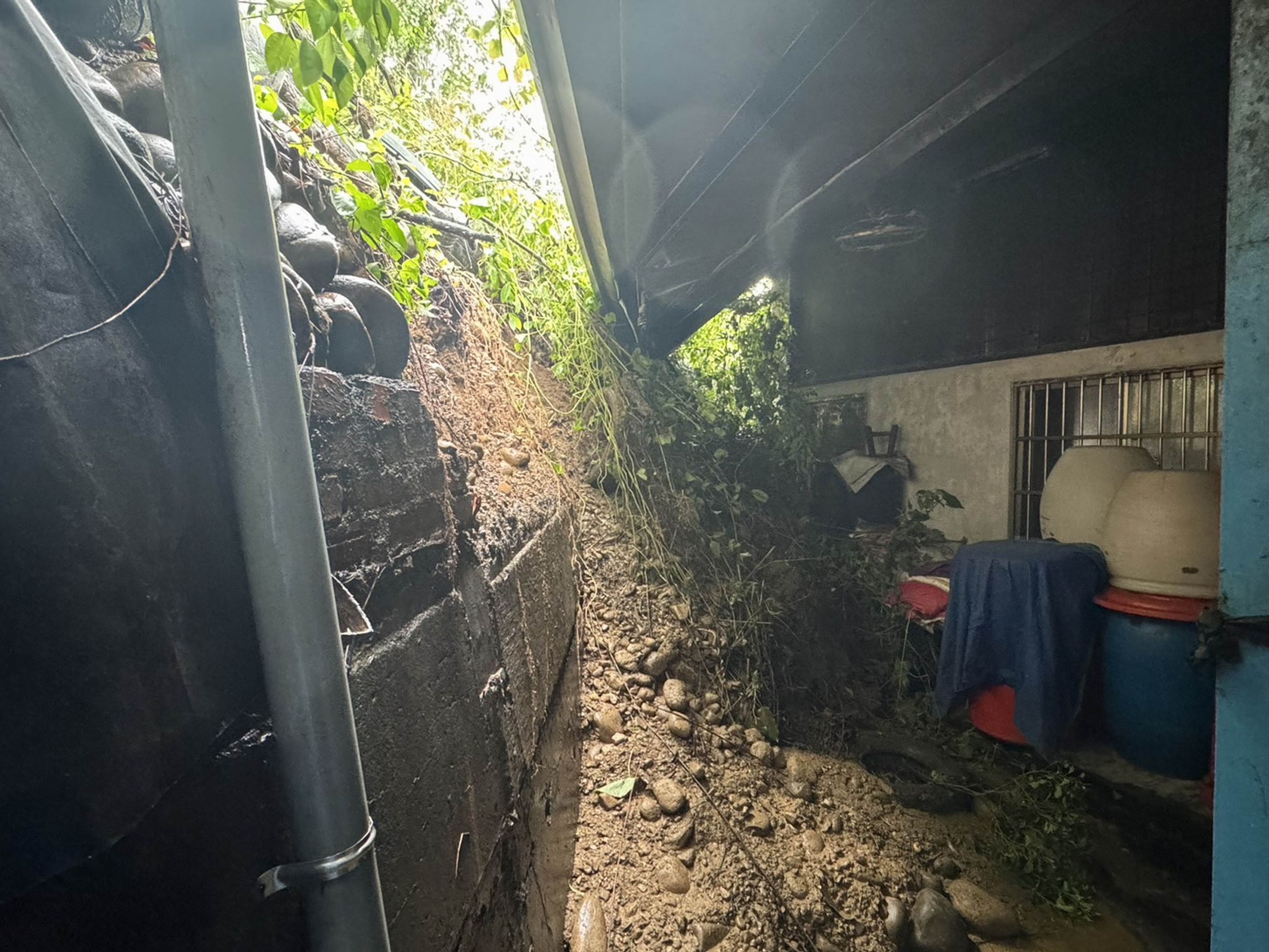 ▲芬園鄉山區的同安村發生土石崩落事件，大片土石邊坡滑落至鐵皮平房後方。（民眾提供）