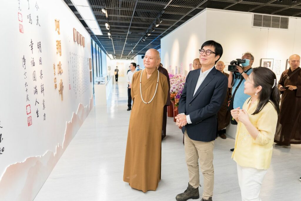 (右起)策展人陳筱君老師為高雄市市長陳其邁及悟道法師導覽