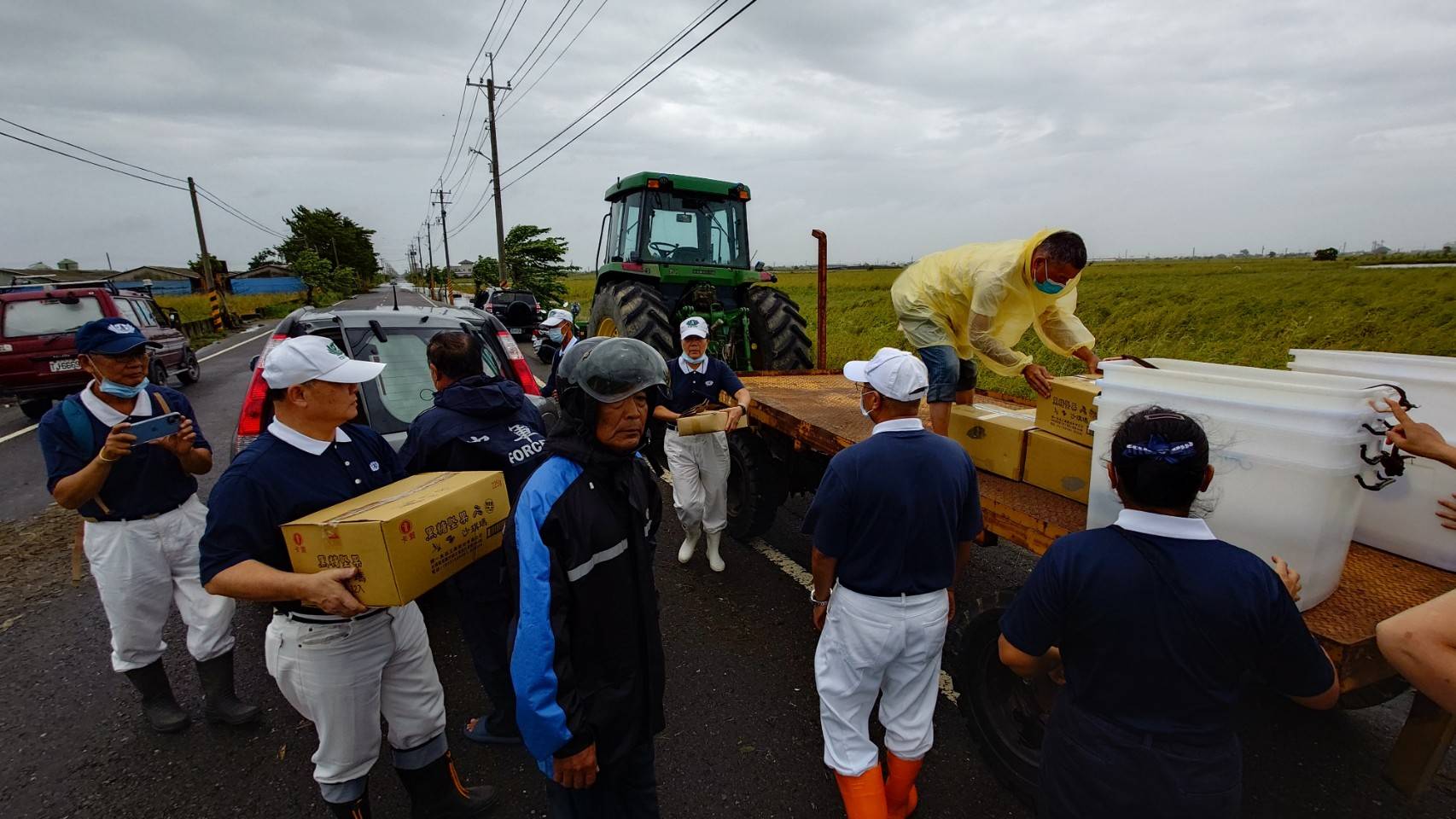 熱心的村民動用大型鐵牛耕耘機,準備載運志工到災區發放便當。(攝影:施哲富)