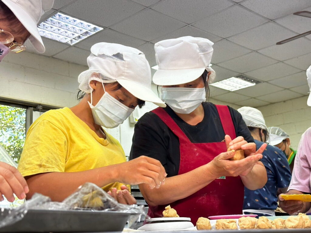 高秋鳳（右）陪伴寶兒（左）適應新環境及熟悉烘焙相關作業。（芥菜種會提供）