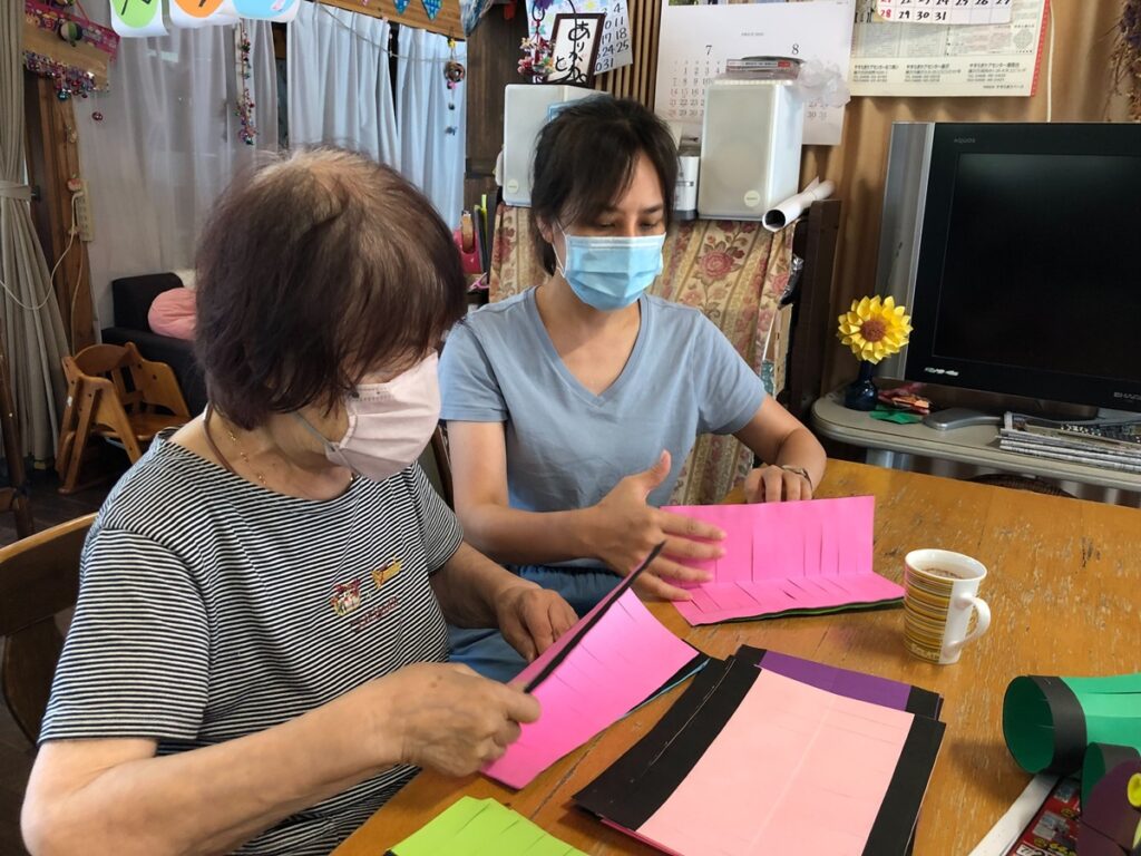 中臺科大王瑞瑩同學與葵照護長者製做燈籠。(圖/中臺科大提供)