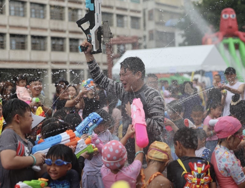 民眾黨立委黃國昌(中)10日下午出席搖滾水樂園活動,與小朋友一同玩水槍,戲水消暑。中央社