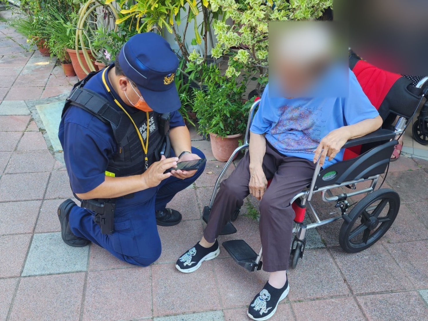 ▲94歲迷途失智劉姓老婦人(右)坐輪椅徘徊酷熱街頭,警二分局博愛派岀所巡佐翁俊郎(左)查出身分及時協助返家。(圖/記者王俊勝 翻攝)