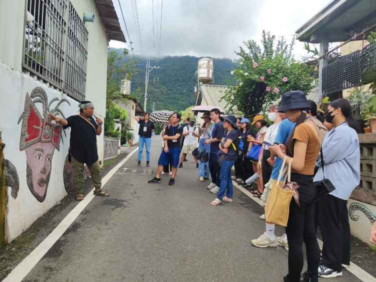 ▲進駐於屏東智慧農業學校的夥伴、青葉部落社區發展協會理事長巴俊傑帶領青年走讀部落，街道上處處可見魯凱族神話故事的藝術牆，彷彿置身戶外美術館。（屏東縣政府提供）