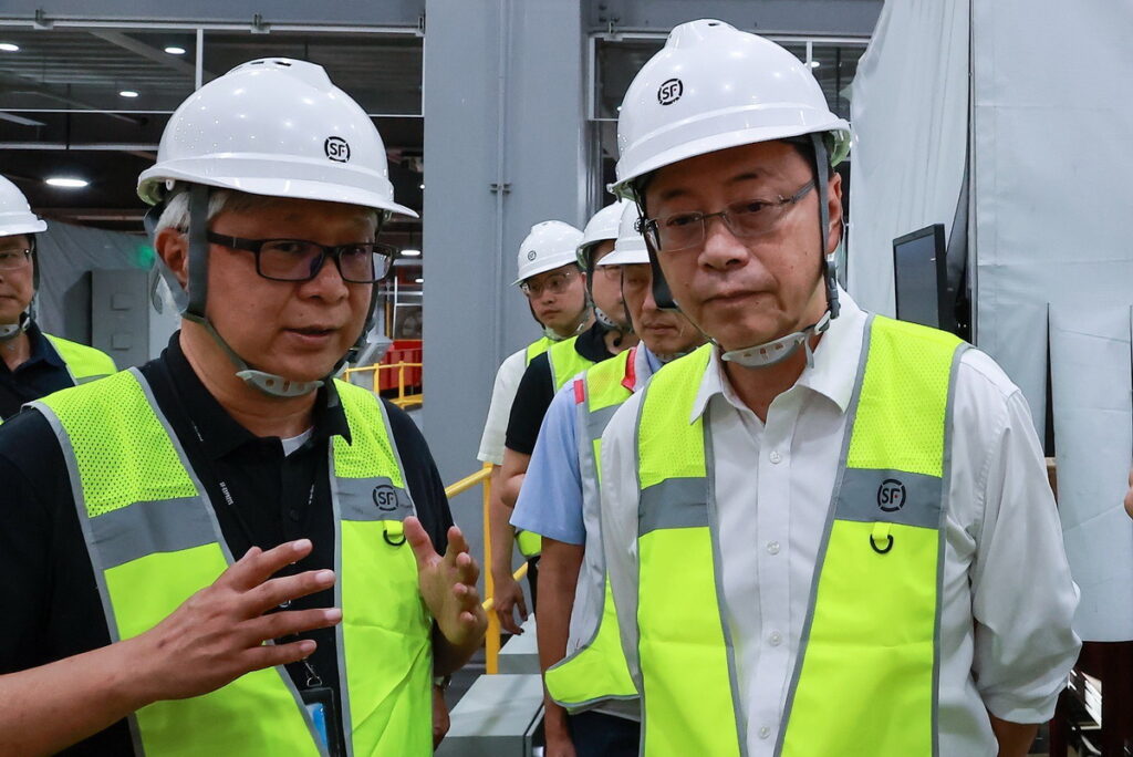台灣順豐總經理潘逸俊向桃園市長張善政說明全自動化分揀設備運作模式，大幅提升貨件轉運效率。