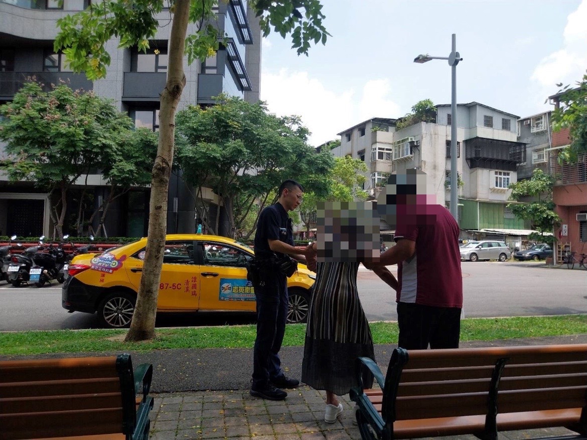老婦疑似中暑坐在公園長椅上,北投分局奇岩派出所警員蔡皇賜 協助聯繫家屬到場。(記者薛秀蓮翻攝)