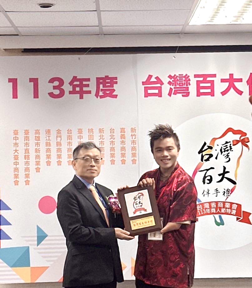 經濟部中小及新創企業署主任秘書謝戎峰（左）親自頒台灣百大伴手禮獎牌給網紅生物科技股份有限公司詹翔欽（右）（圖/記者黃溎芬翻攝）