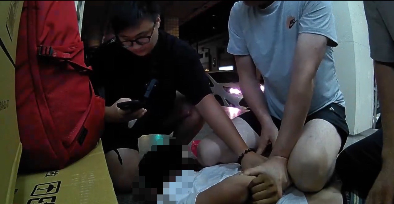 ▲警方一擁而上壓制逮捕陳姓車手。(翻攝畫面)