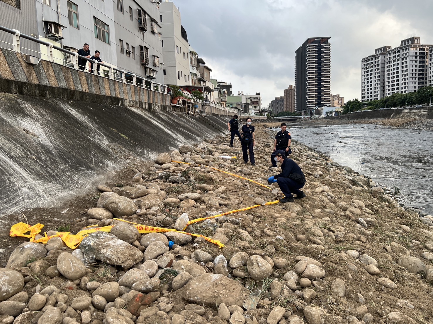 ▲桃園市桃園區警方接獲通報指南崁溪河床有未爆彈,當即封鎖現場並驅離現場圍觀民眾。(翻攝畫面)