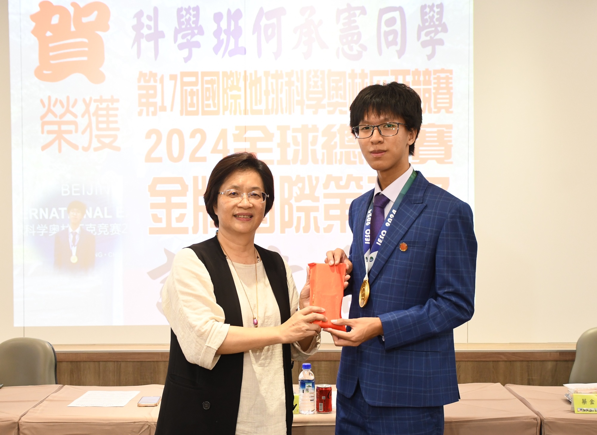▲彰化高中科學班學生何承憲在2024年第17屆國際地球科學奧林匹亞競賽，奪得金牌，彰化縣長王惠美頒贈獎金表揚何承憲，並加冕順澤宮冠軍帽。（記者張溎壕攝）
