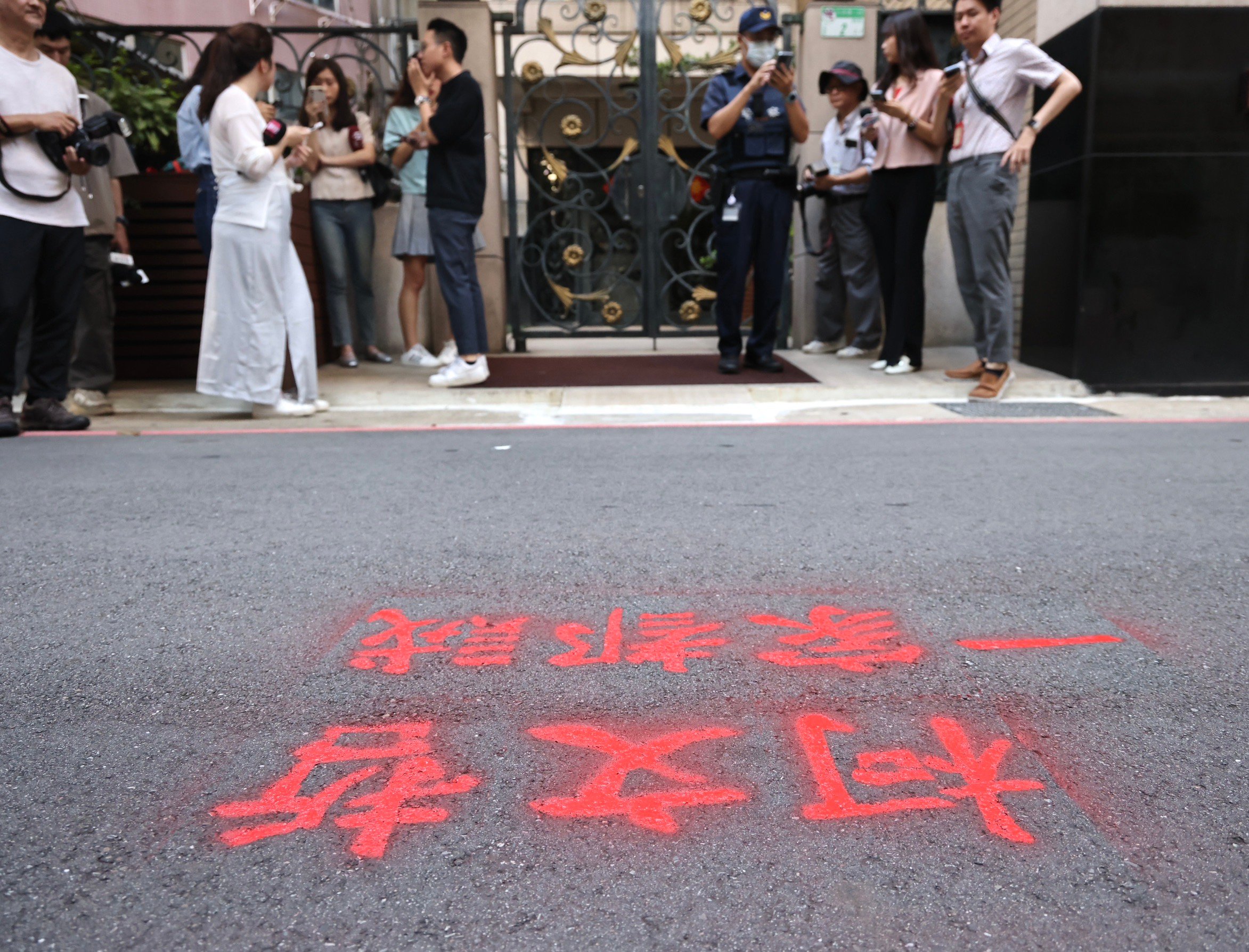 獨派團體「台灣國」22日在柯文哲住家門口柏油路,用紅色噴漆噴上「柯文哲一家都賊」。林啟弘攝