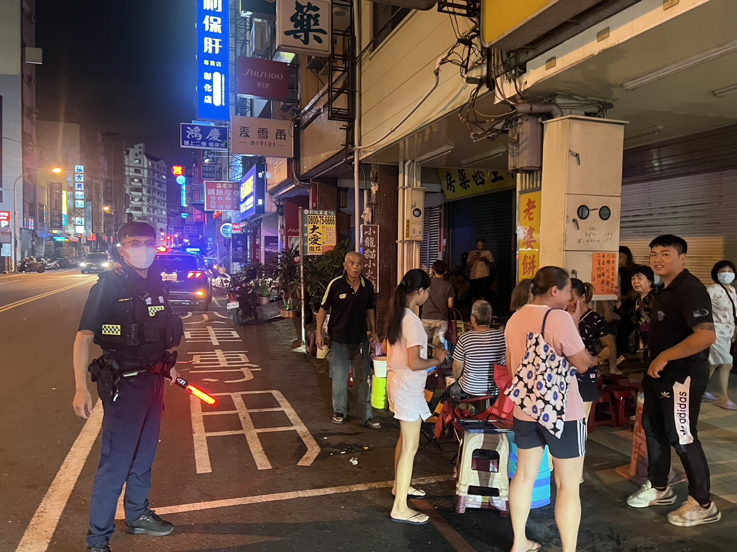 ▲彰化市知名蛋黃酥店「不二坊」近日吸引大量顧客排隊，造成交通混亂和垃圾問題，彰化警分局派員針對違停開單告發。（記者張溎壕攝）