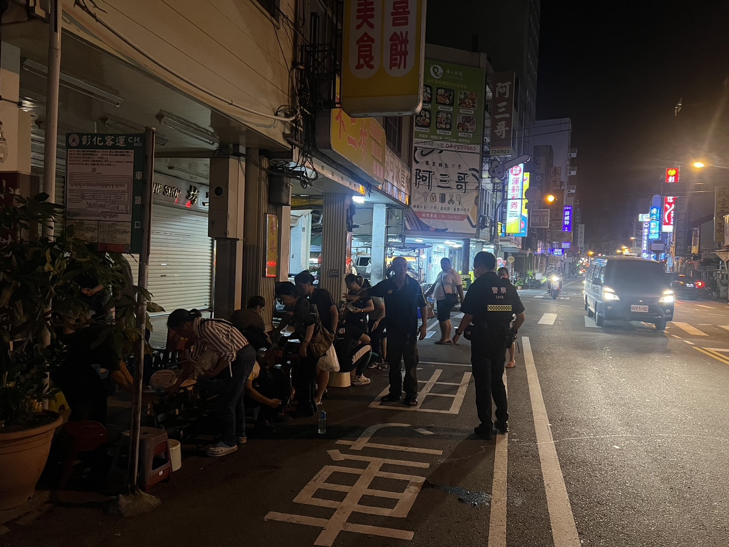 ▲彰化市知名蛋黃酥店「不二坊」近日吸引大量顧客排隊，造成交通混亂和垃圾問題，彰化警分局派員針對違停開單告發。（記者張溎壕攝）