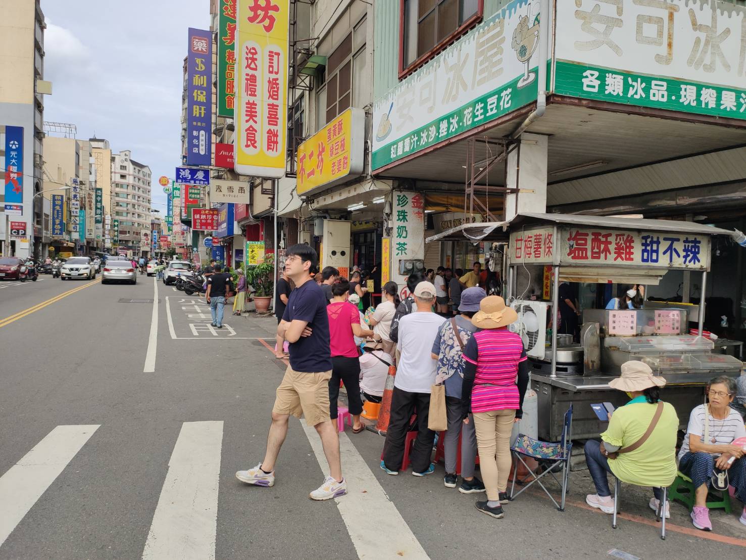 ▲彰化市知名蛋黃酥店「不二坊」近日吸引大量顧客排隊，造成交通混亂和垃圾問題，彰化警分局派員針對違停開單告發。（記者張溎壕攝）