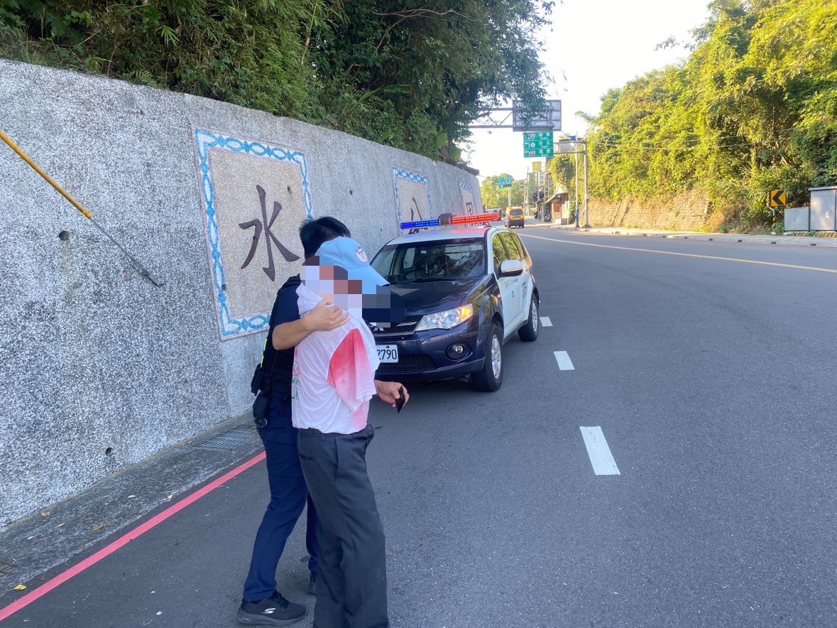 警方於水源橋旁攙扶路倒獨臂老翁。(記者薛秀蓮翻攝)