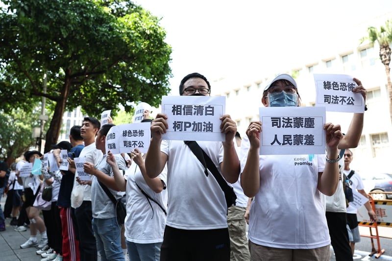 上午北檢外聚集支持柯文哲的民眾,高舉標語聲援。中央社