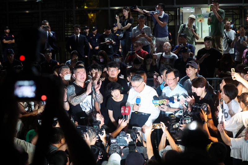 前台北市長柯文哲涉嫌京華城弊案,台北地院2日凌晨裁決無保請回,他(中白衣)向支持者發表談話,但高院4日裁定發回地院更審。圖/中央社