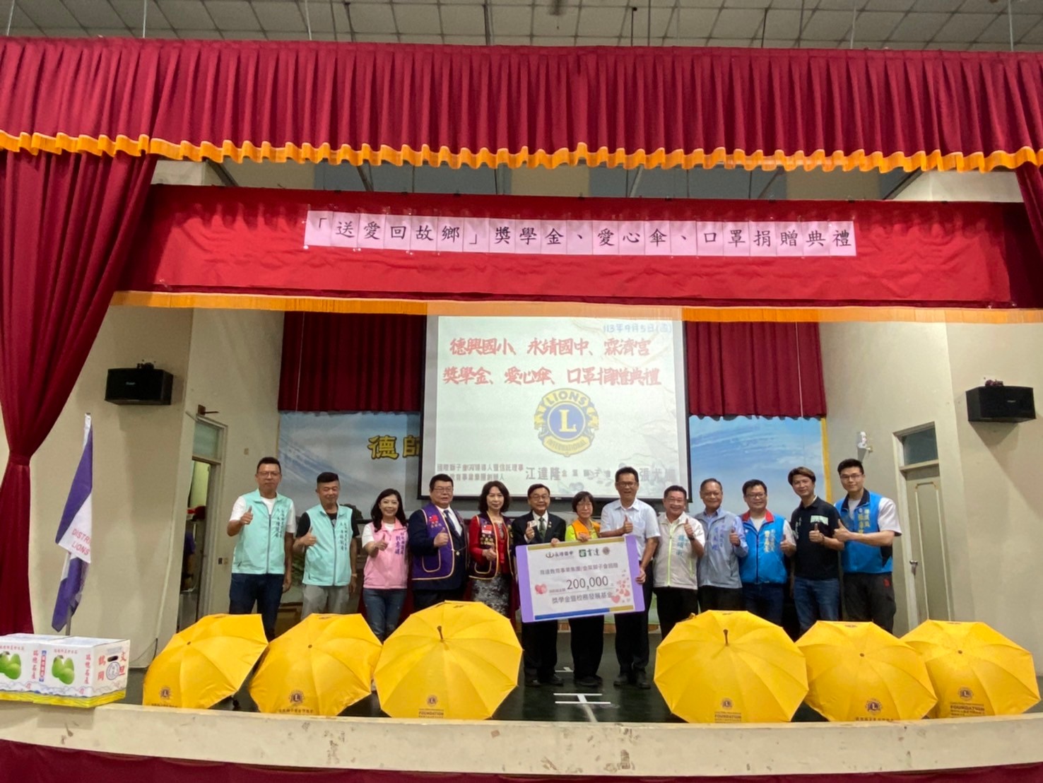 ▲永靖鄉德興國小傑出校友、育達教育基金會董事長江達隆率領國際獅子會捐贈獎學金及愛心傘和口罩，為學校與社區注入豐厚資源與關懷。（記者張溎壕攝）