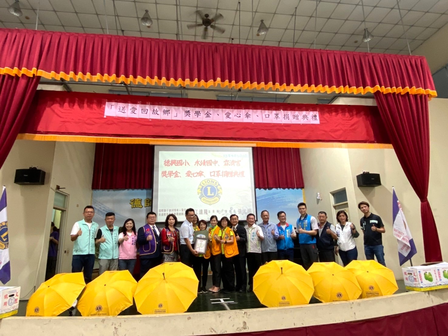 ▲永靖鄉德興國小傑出校友、育達教育基金會董事長江達隆率領國際獅子會捐贈獎學金及愛心傘和口罩，為學校與社區注入豐厚資源與關懷。（記者張溎壕攝）