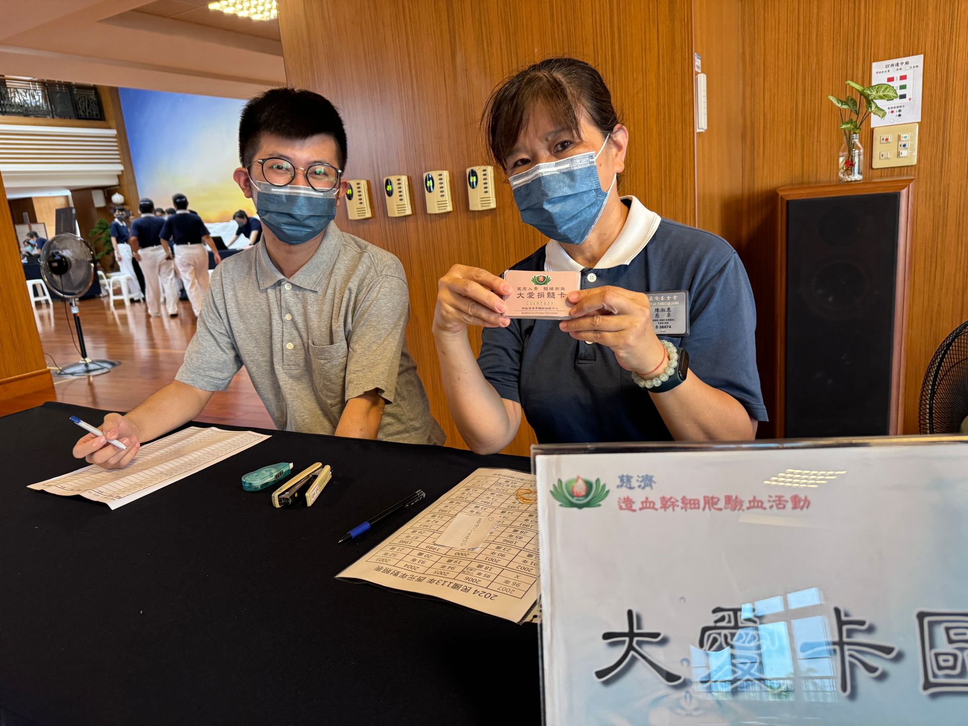 志工陳淑惠(右)與兒子林先生(左)承擔大愛卡區工作人員。