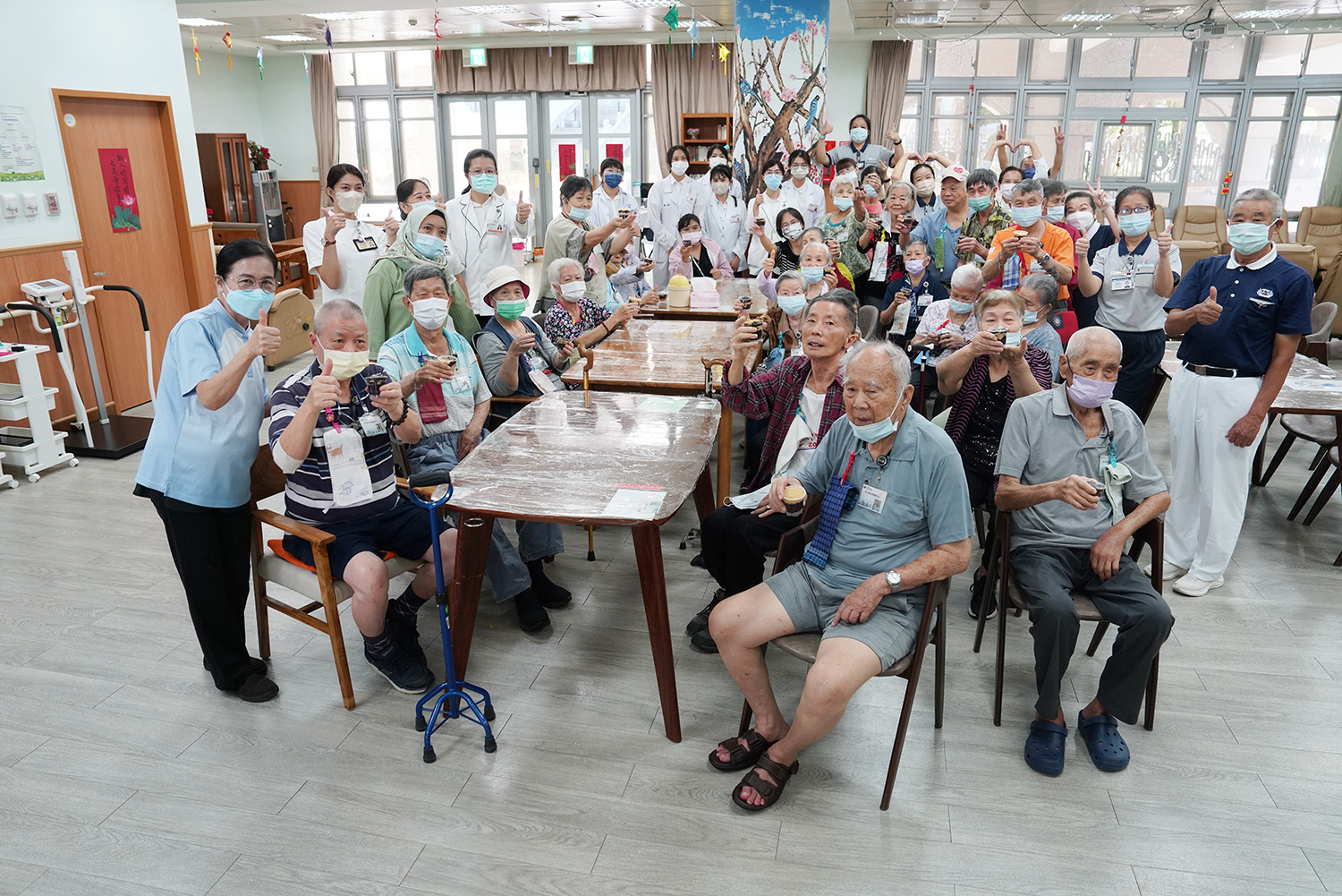 25位同心圓日照中心長輩與照服員、志工、營養師團隊,留下中秋節歡樂紫米金蓉糕慶祝身影。