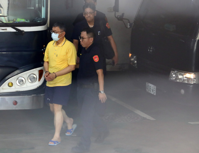 台北地檢署10日首度提訊在押的民眾黨主席柯文哲,柯文哲身穿黃色被告制服、短褲,雙手上銬,腳穿拖鞋。圖/中央社