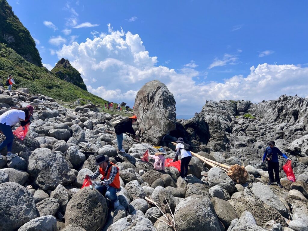 參與者搭船登上基隆嶼,展開大規模淨灘行動,將散落於海岸邊的垃圾徹底清理
