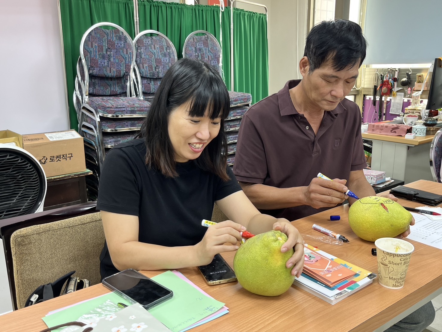 新住民夫妻開心在文旦柚上共同彩繪創作。(記者 張艷君翻攝)