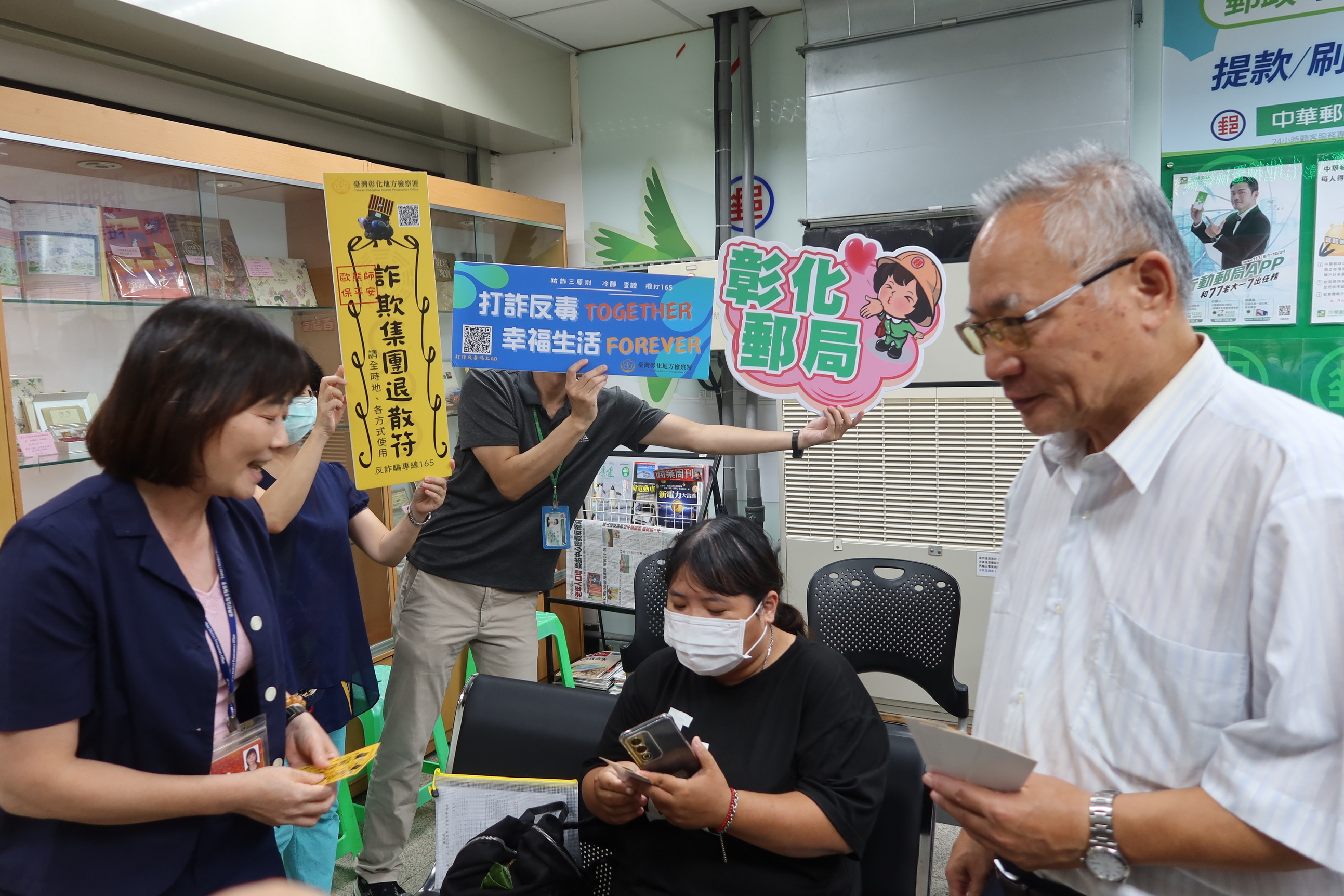 ▲彰化地檢署和彰化郵局攜手合作，在全縣61個郵政支局中，張貼「打詐符咒」宣導文宣，希望提高民眾對詐騙手法的警覺。（記者張溎壕攝）