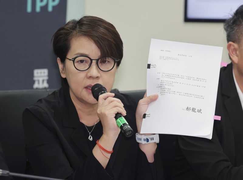 民眾黨立委黃珊珊(右)手拿過去台北市政府通過的都市計畫書例證,說明京華城容積率案。中央社