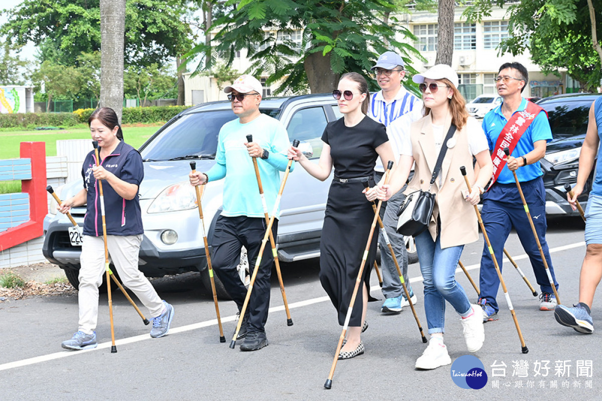 每人雙手各持一支客製化健走竹杖,展開綠能結合綠色隧道健走的行程/陳致愷攝影