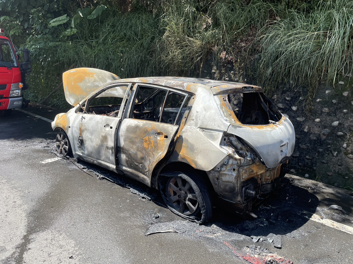 ▲芬園鄉員草路發生一起火燒車事故，駕駛及乘客共3人緊急逃出車外，火勢迅速被撲滅，轎車已被燒成廢鐵，面目全非。（民眾提供）